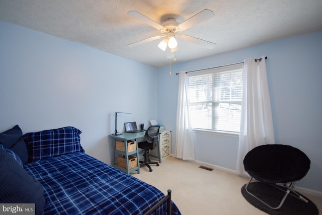 carpeted bedroom with a textured ceiling, visible vents, and baseboards