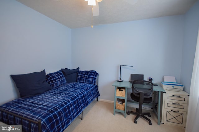 carpeted home office featuring ceiling fan