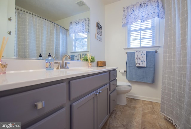 bathroom featuring toilet, visible vents, and vanity