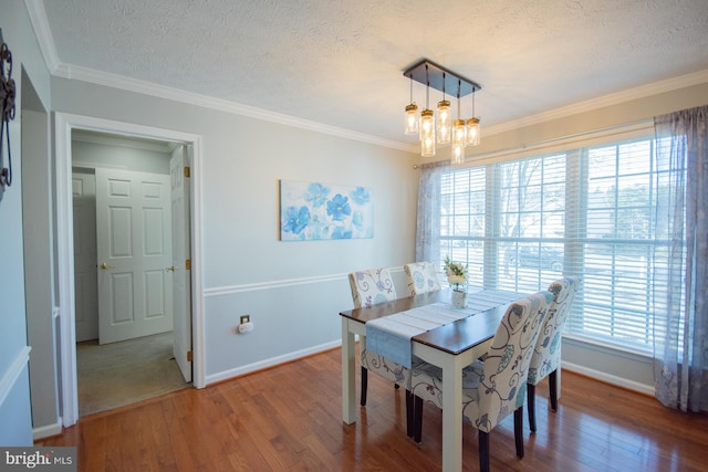 dining space featuring crown molding, a textured ceiling, a chandelier, and wood finished floors