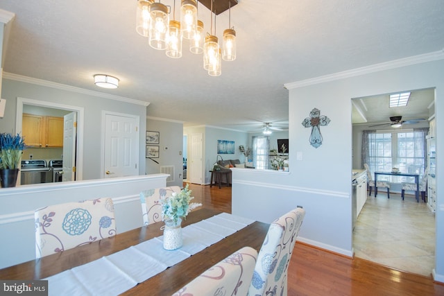 dining space featuring ornamental molding, washing machine and clothes dryer, light wood-style flooring, and baseboards