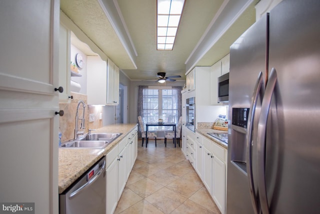 kitchen featuring stainless steel appliances, a sink, and white cabinetry