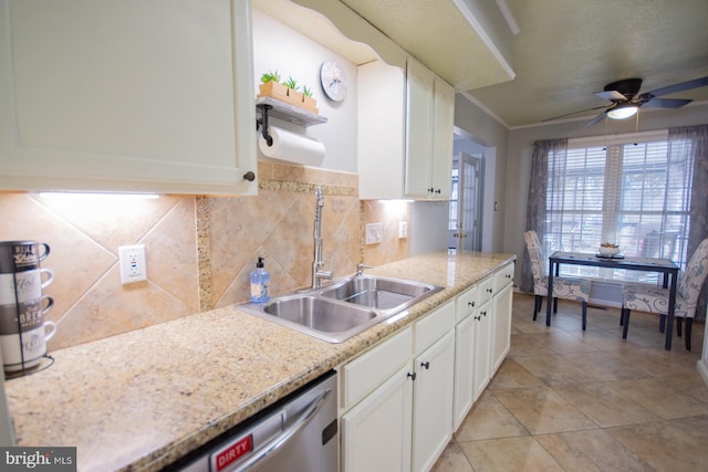 kitchen featuring a sink, white cabinetry, a ceiling fan, stainless steel dishwasher, and tasteful backsplash