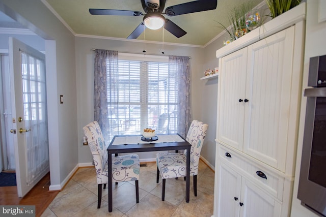 dining space featuring light tile patterned floors, baseboards, and ornamental molding