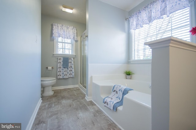 full bath with a garden tub, toilet, a shower stall, wood finished floors, and baseboards