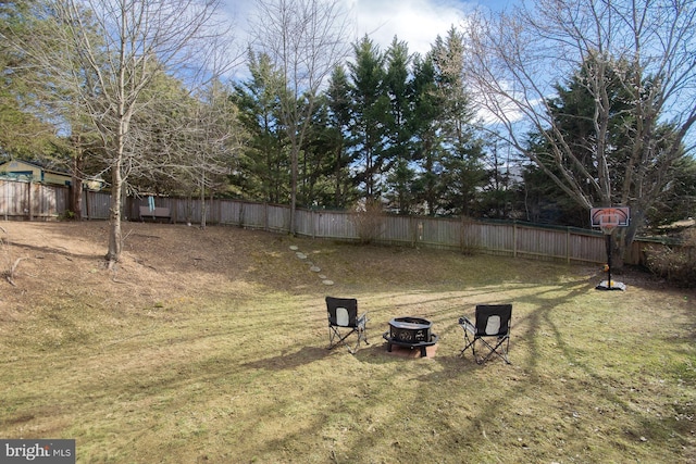 view of yard featuring a fenced backyard and a fire pit