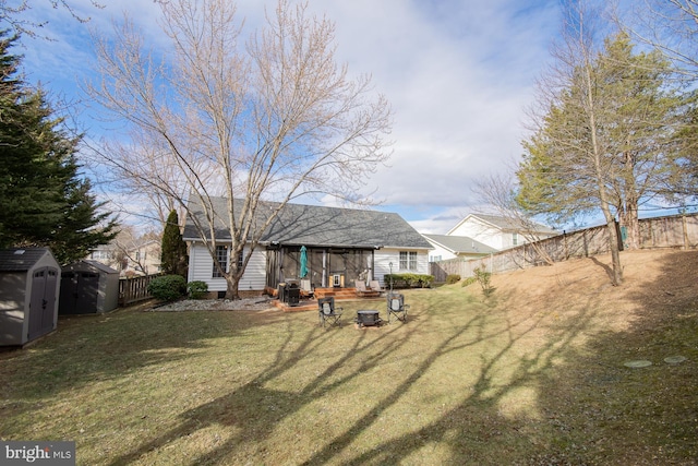 view of yard featuring an outbuilding, a storage unit, and a fenced backyard