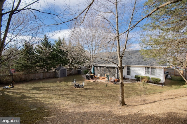 view of yard with a fenced backyard, an outdoor structure, and a storage unit