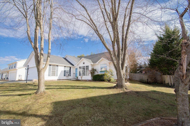 view of front facade with a garage, a front yard, and fence