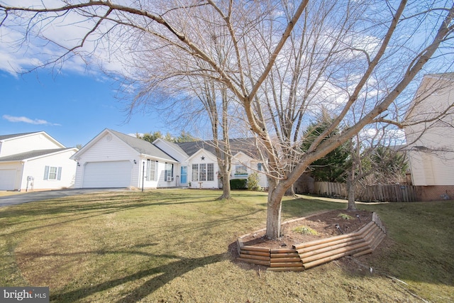 view of front of property with a garage, driveway, a front yard, and fence