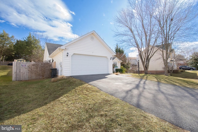 view of side of property with a yard, fence, a garage, and aphalt driveway