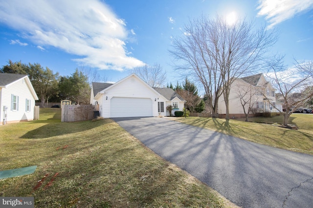 view of front of house featuring aphalt driveway, a front lawn, and an attached garage