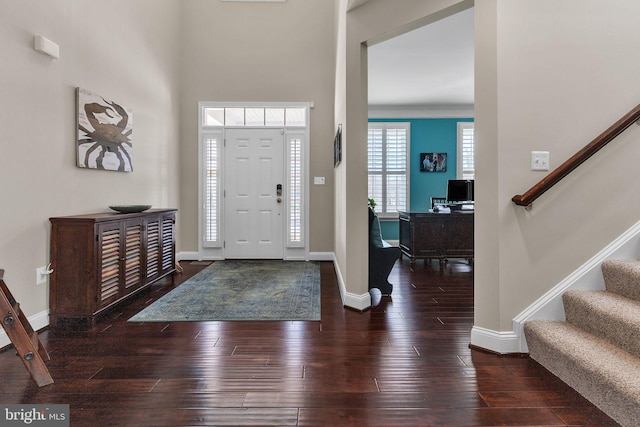 foyer entrance with wood-type flooring, stairway, and baseboards