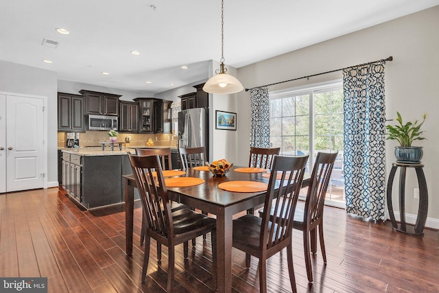 dining room featuring baseboards, visible vents, dark wood-style flooring, and recessed lighting