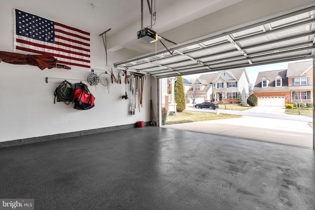 garage with baseboards, a residential view, and a garage door opener