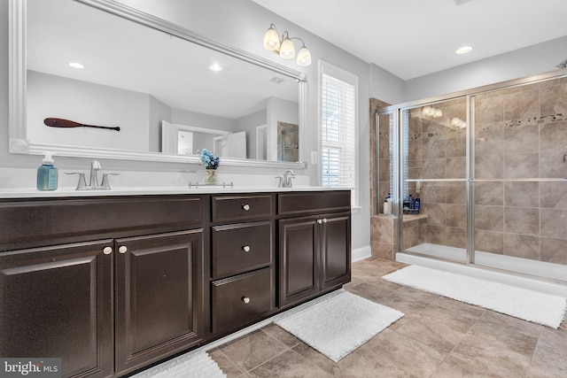 full bath with a sink, double vanity, a shower stall, and recessed lighting