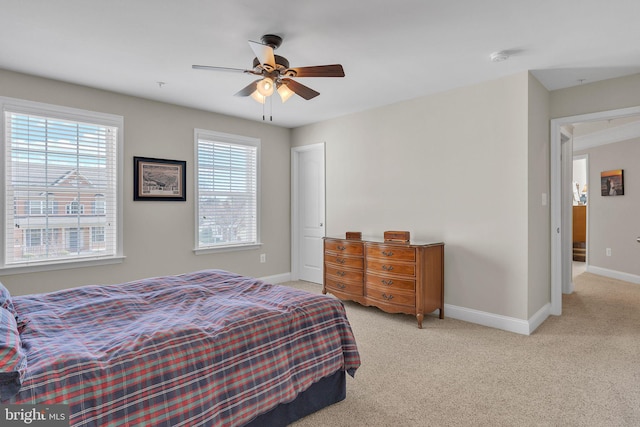 bedroom with light carpet, ceiling fan, and baseboards