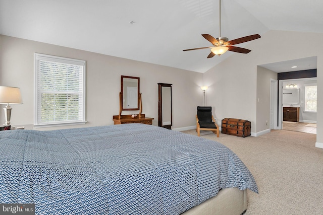 carpeted bedroom with vaulted ceiling, ensuite bath, baseboards, and ceiling fan