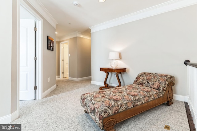 sitting room with carpet flooring, crown molding, and baseboards