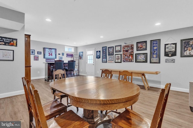 dining area featuring a dry bar, light wood-type flooring, recessed lighting, and baseboards