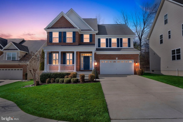 craftsman house with driveway, an attached garage, covered porch, a front lawn, and brick siding