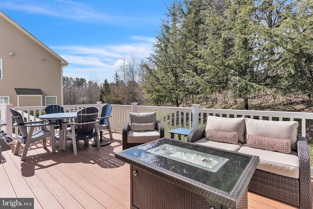 wooden terrace with outdoor dining space and an outdoor living space with a fire pit