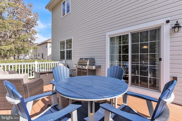 wooden terrace featuring outdoor dining space and area for grilling