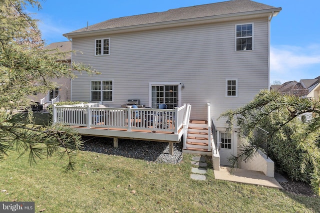 rear view of property featuring a deck and a lawn