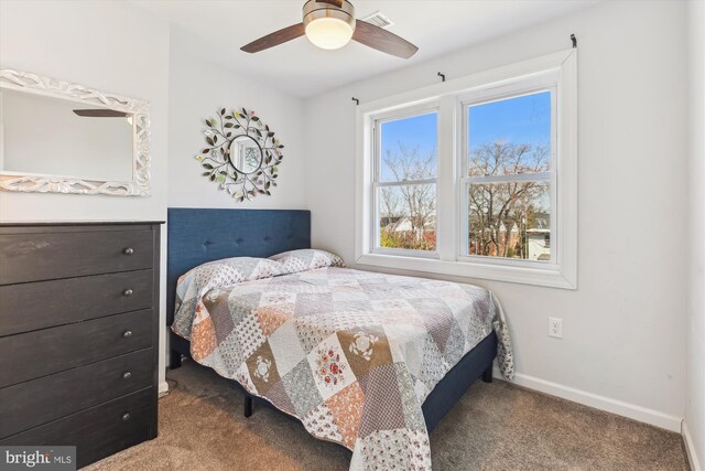 carpeted bedroom with visible vents, baseboards, and ceiling fan