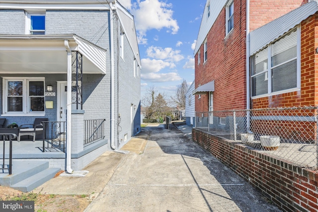 view of property exterior featuring brick siding and a porch