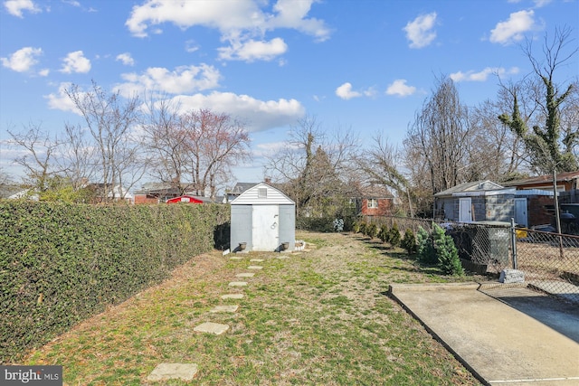 view of yard featuring an outdoor structure, a storage shed, and a fenced backyard