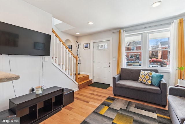 living area with light wood finished floors, stairway, recessed lighting, and baseboards