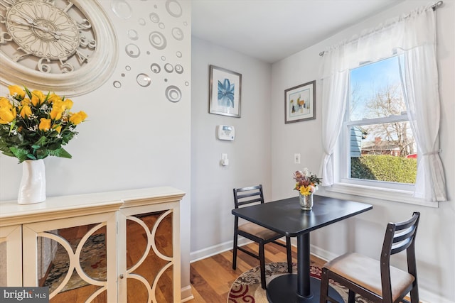 dining space featuring baseboards and wood finished floors