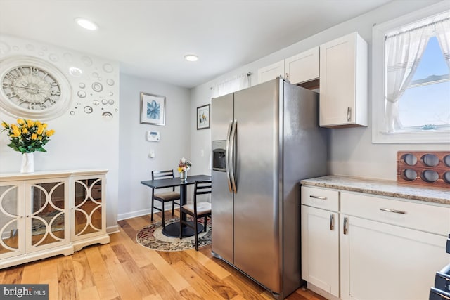 kitchen with baseboards, recessed lighting, white cabinets, light wood-style floors, and stainless steel fridge