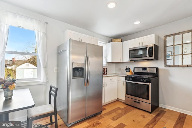 kitchen featuring light wood-style flooring, white cabinetry, recessed lighting, appliances with stainless steel finishes, and light countertops