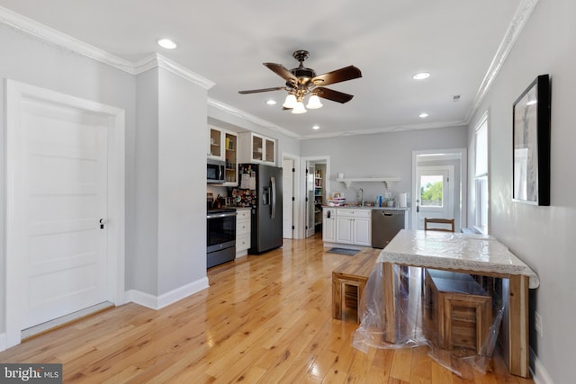 kitchen with light wood finished floors, ceiling fan, a sink, light countertops, and appliances with stainless steel finishes