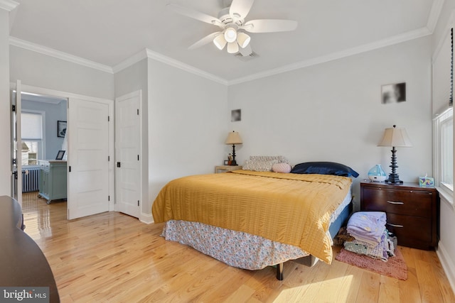 bedroom with crown molding, radiator heating unit, wood finished floors, and visible vents