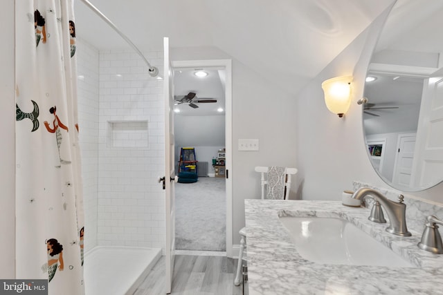 bathroom featuring vanity, wood finished floors, a ceiling fan, and a tile shower