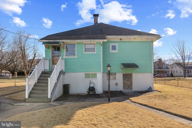 rear view of house with a patio, fence, and a chimney