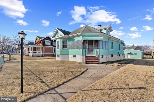 view of front of home with entry steps, a front yard, and fence