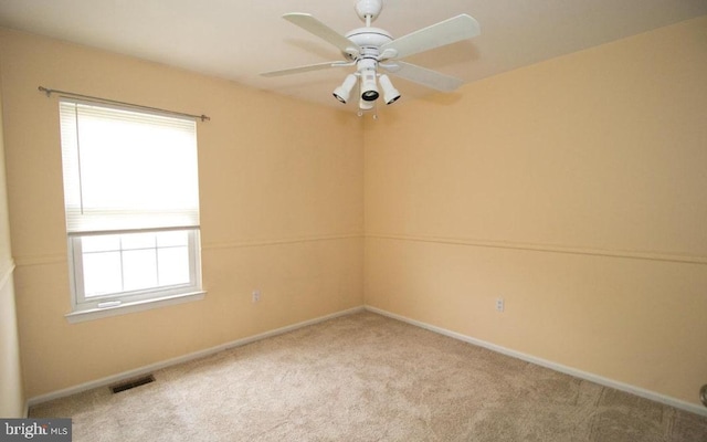 empty room featuring carpet, visible vents, ceiling fan, and baseboards