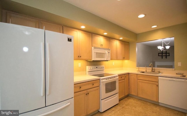 kitchen with white appliances, a sink, light countertops, a notable chandelier, and recessed lighting