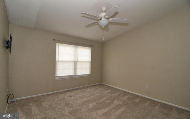 carpeted empty room with lofted ceiling, ceiling fan, and baseboards