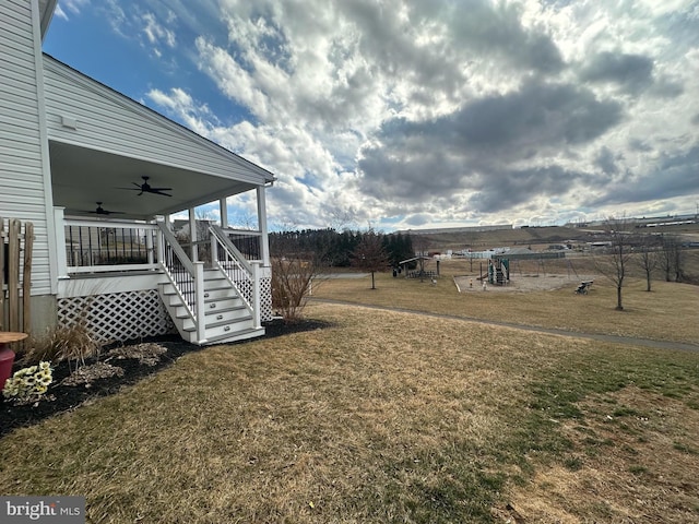 view of yard with a playground and a ceiling fan