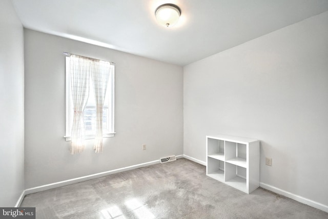 unfurnished room featuring carpet, visible vents, and baseboards