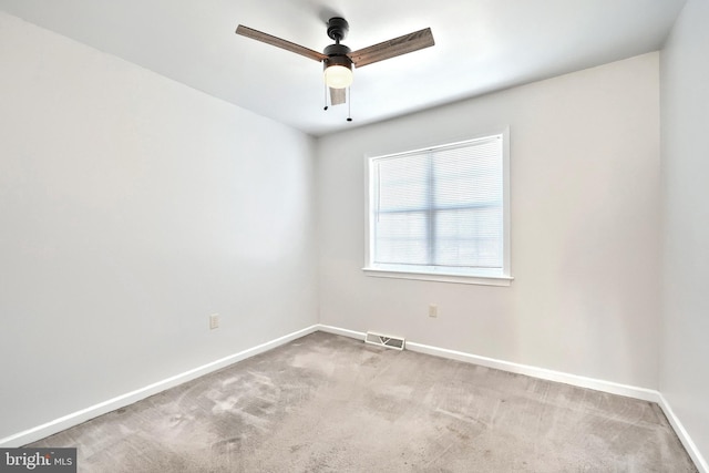 carpeted empty room with a ceiling fan, visible vents, and baseboards