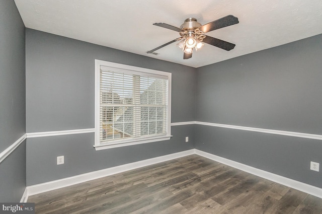unfurnished room with a ceiling fan, baseboards, dark wood finished floors, and visible vents