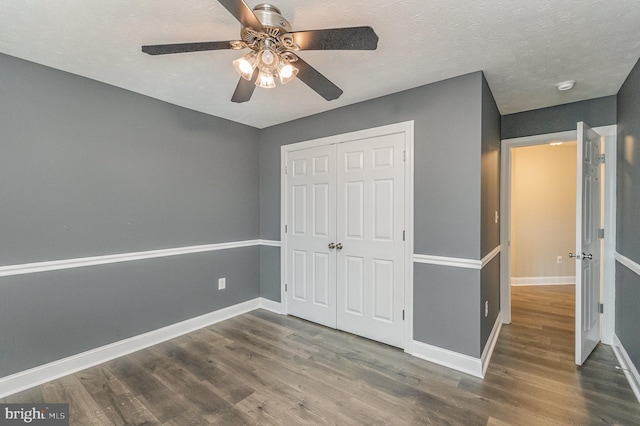 unfurnished bedroom featuring dark wood-style flooring, baseboards, and a closet