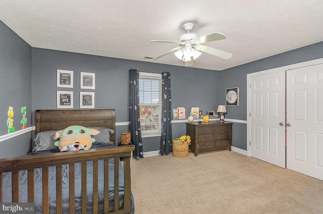 bedroom with visible vents, a closet, baseboards, ceiling fan, and carpet