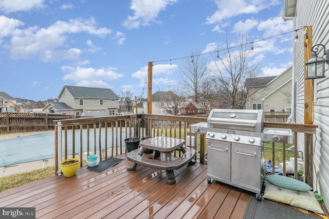 wooden deck with fence, a residential view, and a grill